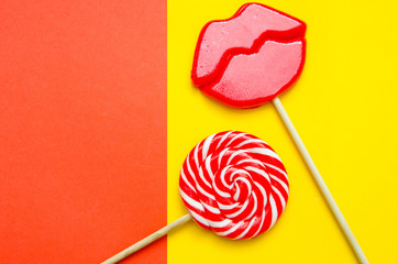 two lollipops on a red and yellow background