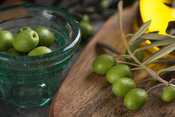 Glas cup of olives with extra virgin olive oil in glass bottle on rustic background. close up