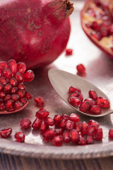 Pomegranate seeds on the spoon with pomegranate juice in a glass on the silver tray close view 4