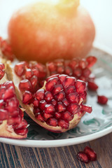 Opened pomegranate with scattered seeds on the silver tray toned 2