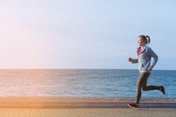 Shot of a beautiful athletic woman training at sunrise.