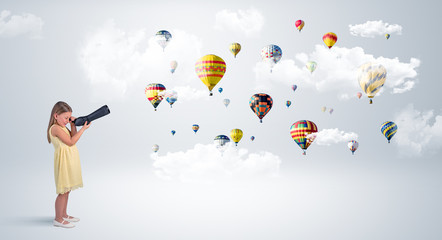 Cute girl looking to air balloons through a telescope
