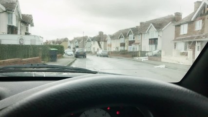 A dirty car windscreen being cleaned using the screenwash and wipers.