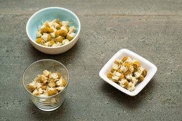 dried chamomiles on dark wooden table