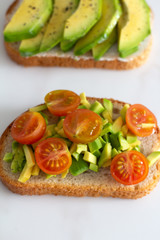 toast with avocado and tomatoes close-up on a white background.