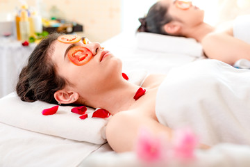 Obraz na płótnie Canvas Beauty young asian woman relax and lying on massage bed in spa salon.Traditional thai oriental aromatherapy and Massage beauty treatments with fresh sliced tomatoes mask on her face for spa treatment.