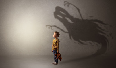 Obraz na płótnie Canvas Scary ghost shadow in a dark empty room with a cute blond child 