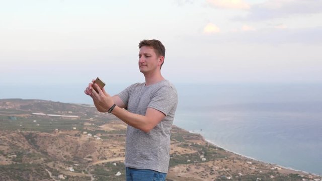 Man take selfie photo against sea on mountain top, Crete, Greece