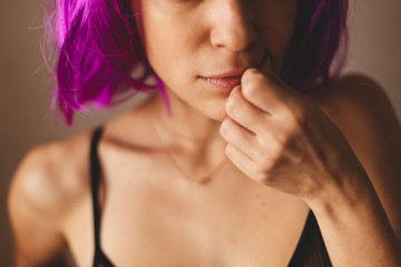 Obraz premium Girl wear pink wig. Beautiful woman with beauty face applying lip balsam, lipbalm on full sexy lips. Portrait of sexy female model with soft skin and natural nude makeup touching lips. High resolution