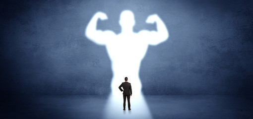 Businessman standing and dreaming about a strong superhero