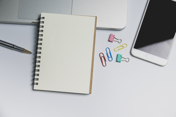 White office desk,  computer keyboard, mobile phone and other office supplies on table. Top view with copy space, flat lay.