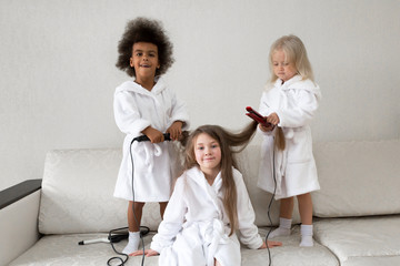 Hair care in children. Baby hairstyles. Girls 5-7 years old make each other hair on their heads.