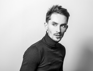 Handsome young elegant man in golf. Black-white studio photo.