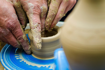 Making it together. Top view of potter teaching child to make ceramic pot on the pottery wheel. pottery workshop