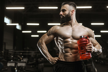 Fototapeta na wymiar Handsome strong athletic muscles men drink water and sport nutrition workout bodybuilding concept background