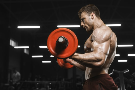 Handsome strong athletic men pumping up muscles workout barbell curl bodybuilding concept background