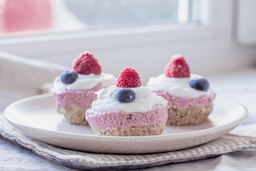 homemade cake with raw strawberries and cashew cream on almond nut dough, healthy vegan food concept. close up