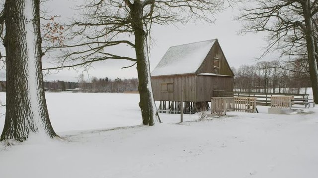 Pfahlhaus im schneebedeckten und zugefrorenen Hausteich bei Plothen im Dreba-Plothener Teichgebiet