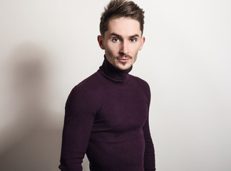 Handsome young elegant man in violet golf.