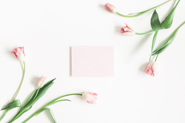 Valentine's Day composition. Tulip flowers, envelope on white background. Valentines day, mothers day, womens day concept. Flat lay, top view, copy space