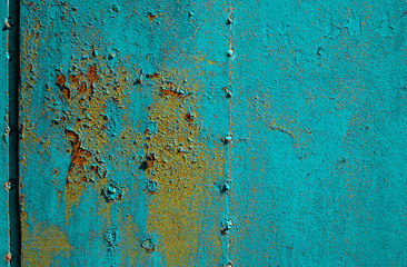 Texture of old rusty metal, painted blue which becames orange from rust. Horizontal texture of cracks and peels paint on rusty welded steel sheets