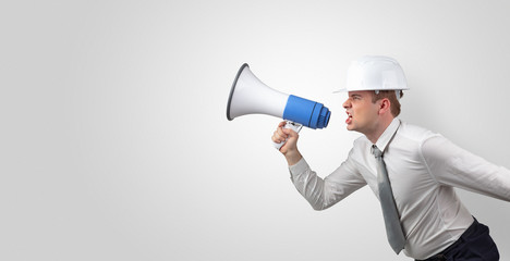 Fototapeta premium Young architect constructor yelling with megaphone and copyspace