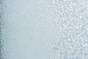 Winter background with gleaming ice. Frozen water texture. Copy space.