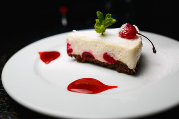 Cheesecake with cherries on a white plate