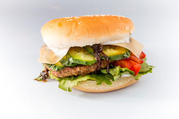 tasty burger with cheese and vegetables on a white background