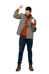 Naklejka premium Full-length shot of Handsome man with beard celebrating a victory on isolated white background
