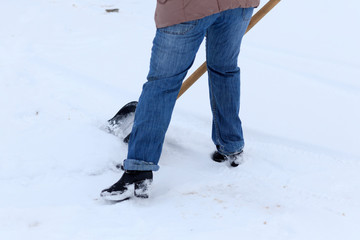 Winter is a lot of snow. A young girl, cleans, proud of doing the big shovel work