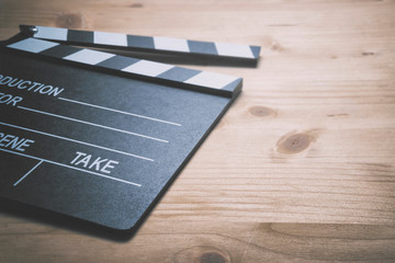 Take action. Movie clapper board on wooden background.
