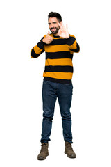 Full-length shot of Handsome man with striped sweater showing ok sign with and giving a thumb up gesture on isolated white background