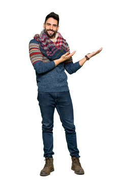 Full-length shot of Hippie man extending hands to the side for inviting to come on isolated white background