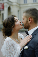 the groom in a gray suit and the bride in a gray dress look at each other, closeup portrait