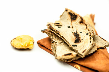 Obraz na płótnie Canvas Close up of common or main ingredients of Malida isolated on white which are rot or bajri ki roti with jaggery in a small glass plate.