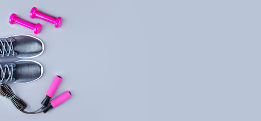 Flat lay shot of sneakers, jumpung rope and dumbbells.