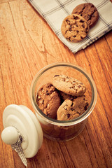 home made chocolate chips cookies biscuits in a glass jar in rustic style 
