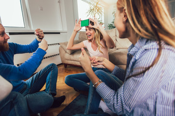 Happy group of friends playing charades at home