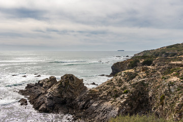 Beautiful view over cliffs and rocks in the ocean. Cloudy day. Nature scenery.
