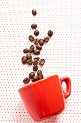  red espresso cup fallen with coffee beans spilled out