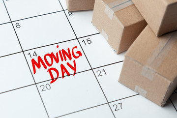 Moving day on the calendar is written in red. Calendar with a note with cardboard boxes.