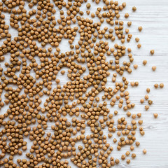 Dried chickpeas on a white wooden  background, top view. Flat lay, overhead, from above.