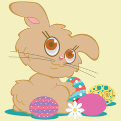 Tan bunny rabbit in a field of Easter eggs