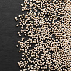 Dried chickpeas on a dark black background, overhead view. Flat lay, top view, from above.