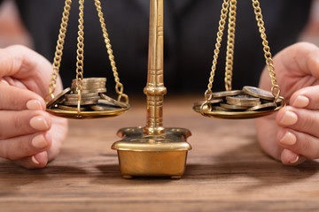 Close-up Of Hand Protecting The Coins On Scale