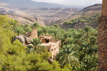 Detail of an old house in the village of Misfat al Abriyyin between date palms and the valley in the background - obrazy, fototapety, plakaty