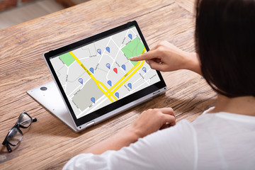 Woman Using GPS Navigation Map On Digital Laptop