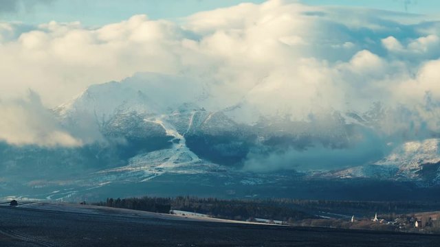 Timelapse of moving clouds over Lomnicky stit peak in High Tatras rocky mountains, Slovakia. Windy winter day.