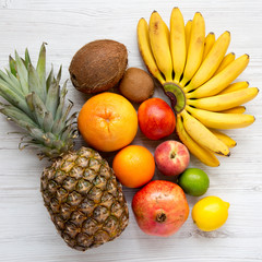 Set of fresh fruits on a white wooden table, top view. From above, overhead.